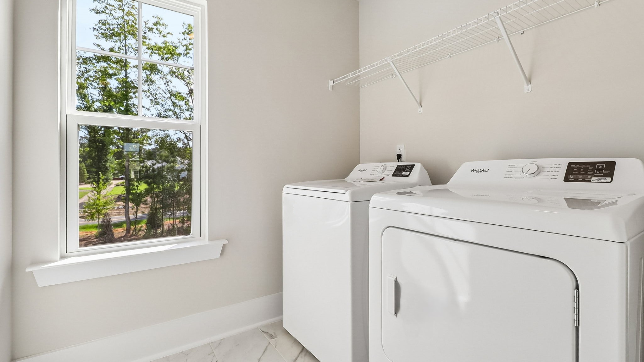 Laundry room upstairs with tile flooring, a window, and shelving above