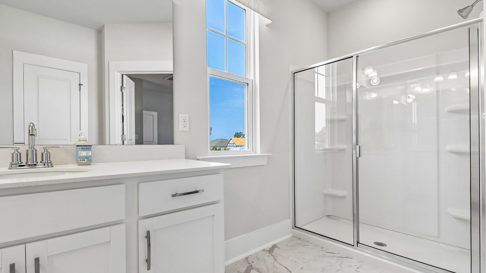 En-suite primary bathroom with walk-in primary shower and tile floors