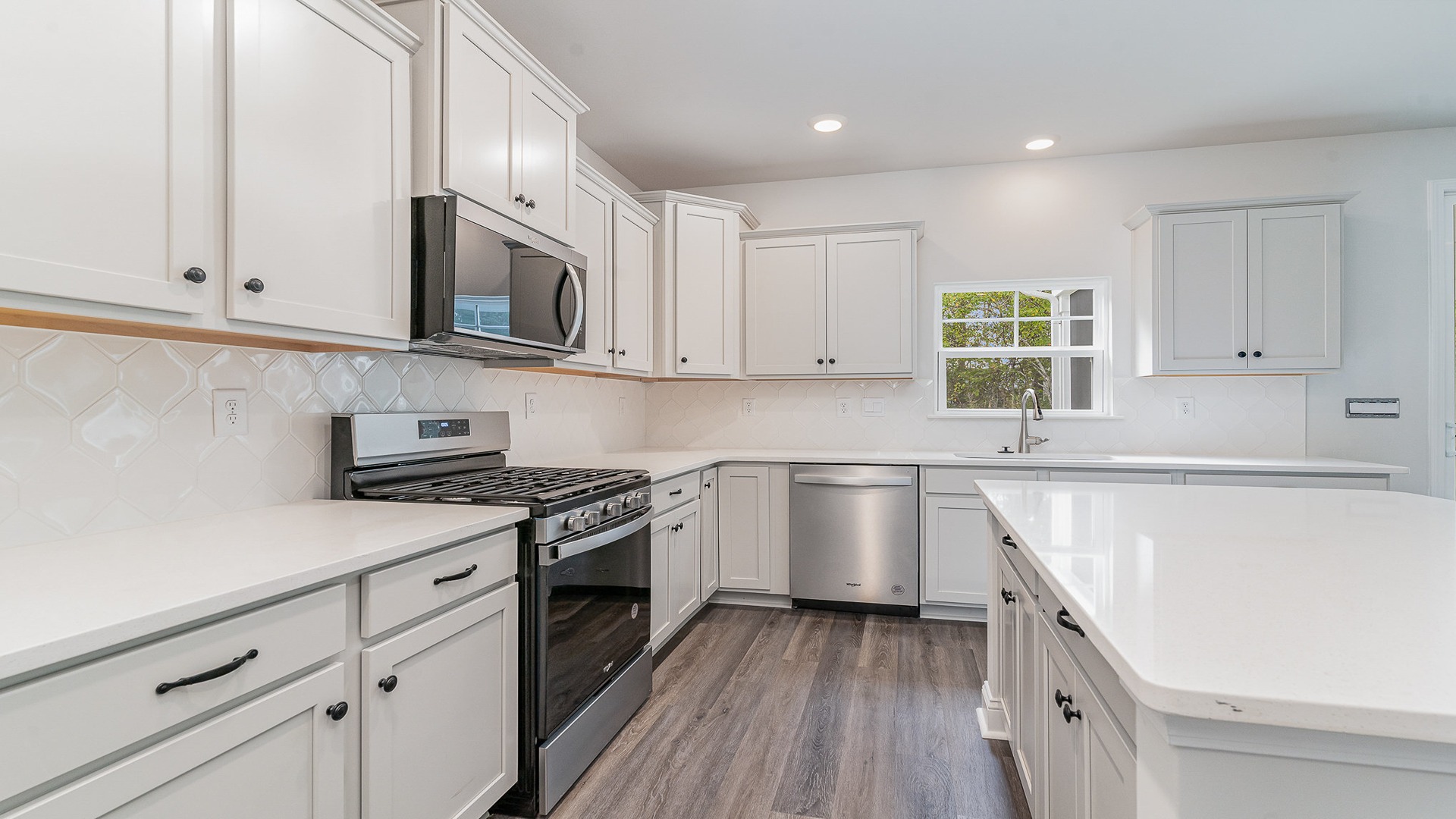 Tile backsplash and stainless-steel appliances finish the kitchen in the Westerly for sale in Shell Pointe