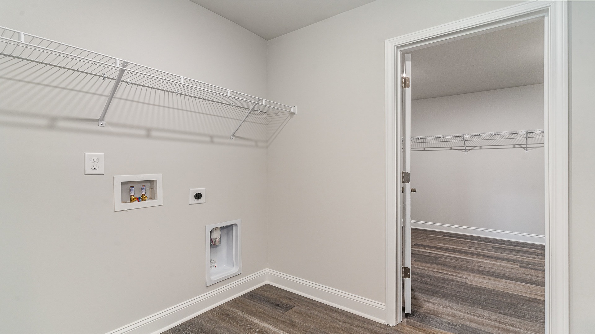 Laundry room upstairs with shelving above