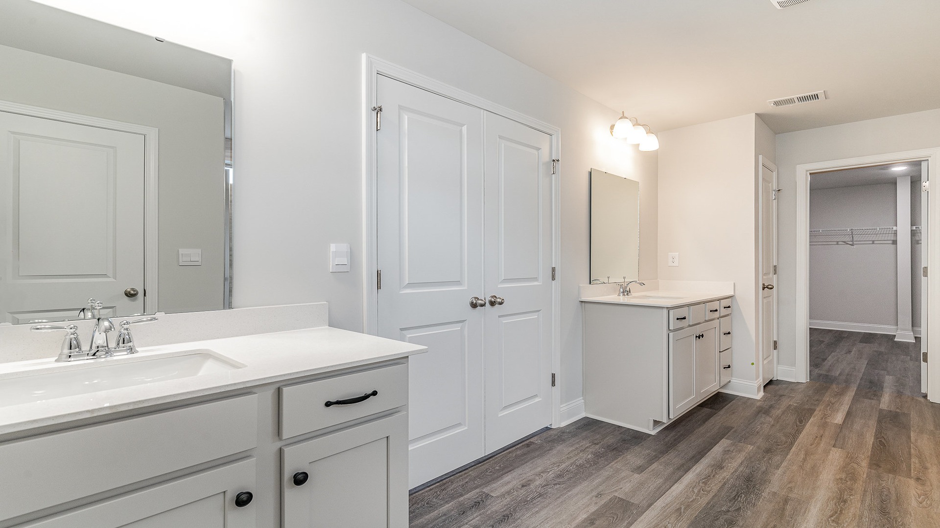 Primary bathroom with 2 vanities and a standup shower with glass front