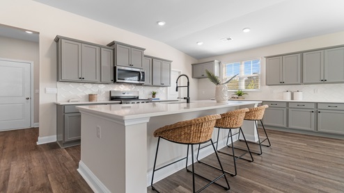 The kitchen comes finished with tile backsplash and quartz countertops