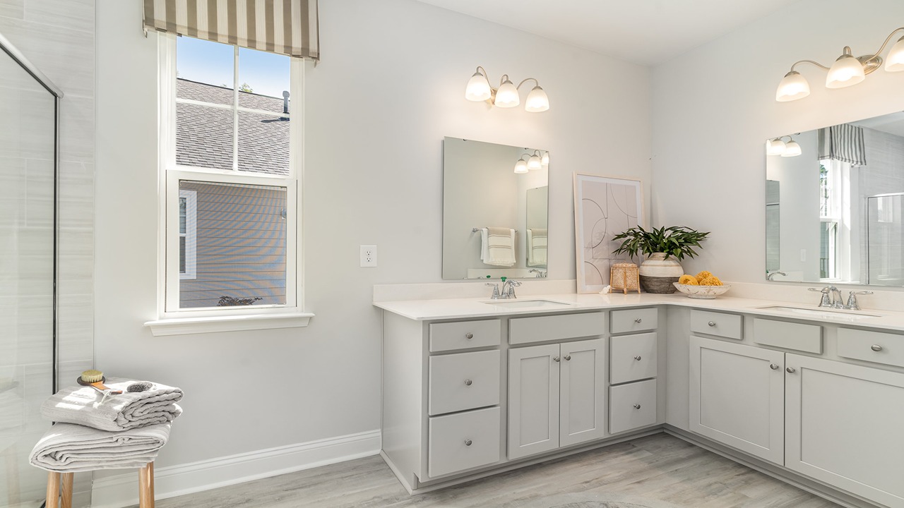 Two primary vanities with cabinetry and sinks