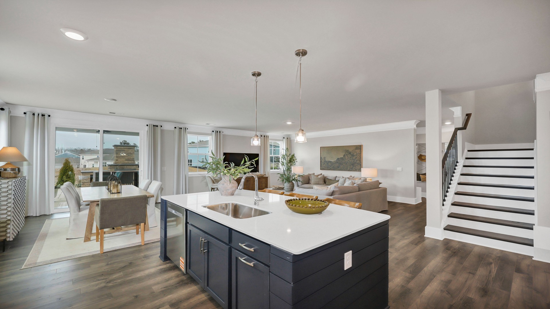 Kitchen island overlooks main living areas and stairway to upstairs