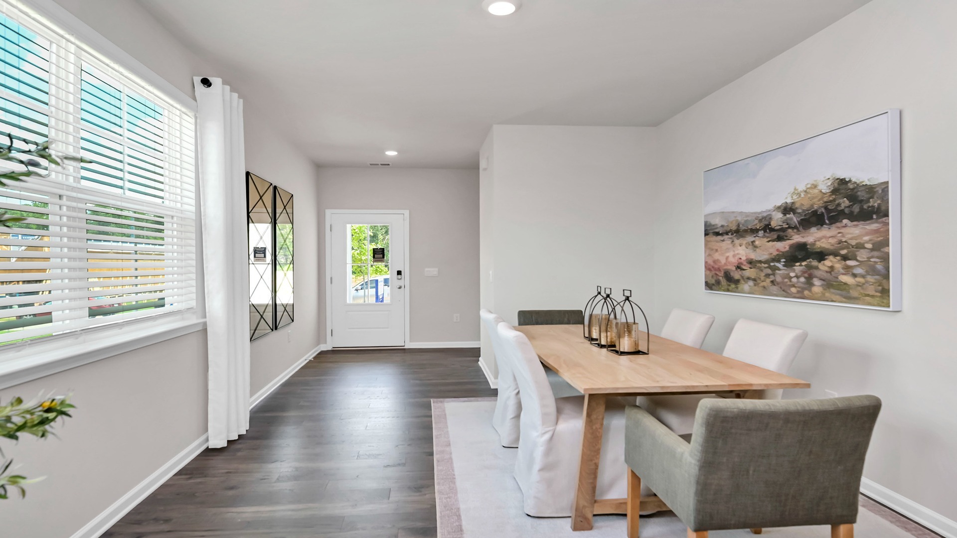 Entrance through the front door leads into the foyer and dining areas.