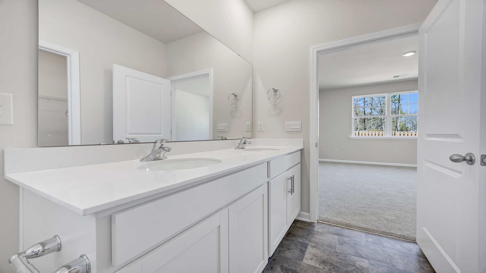 There are double sinks and cabinetry in the primary bathroom.