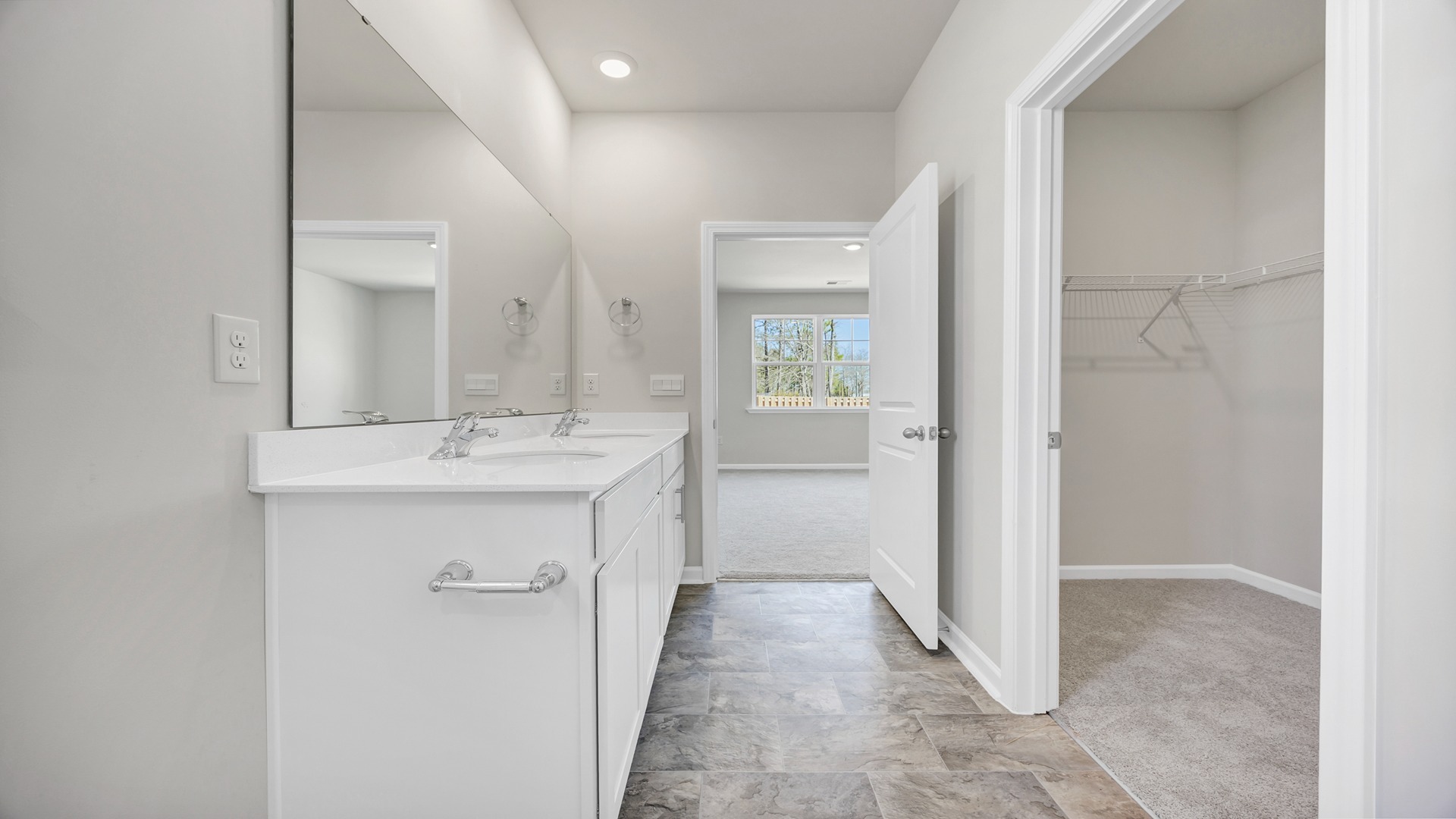 There are double sinks and cabinetry in the primary bathroom.