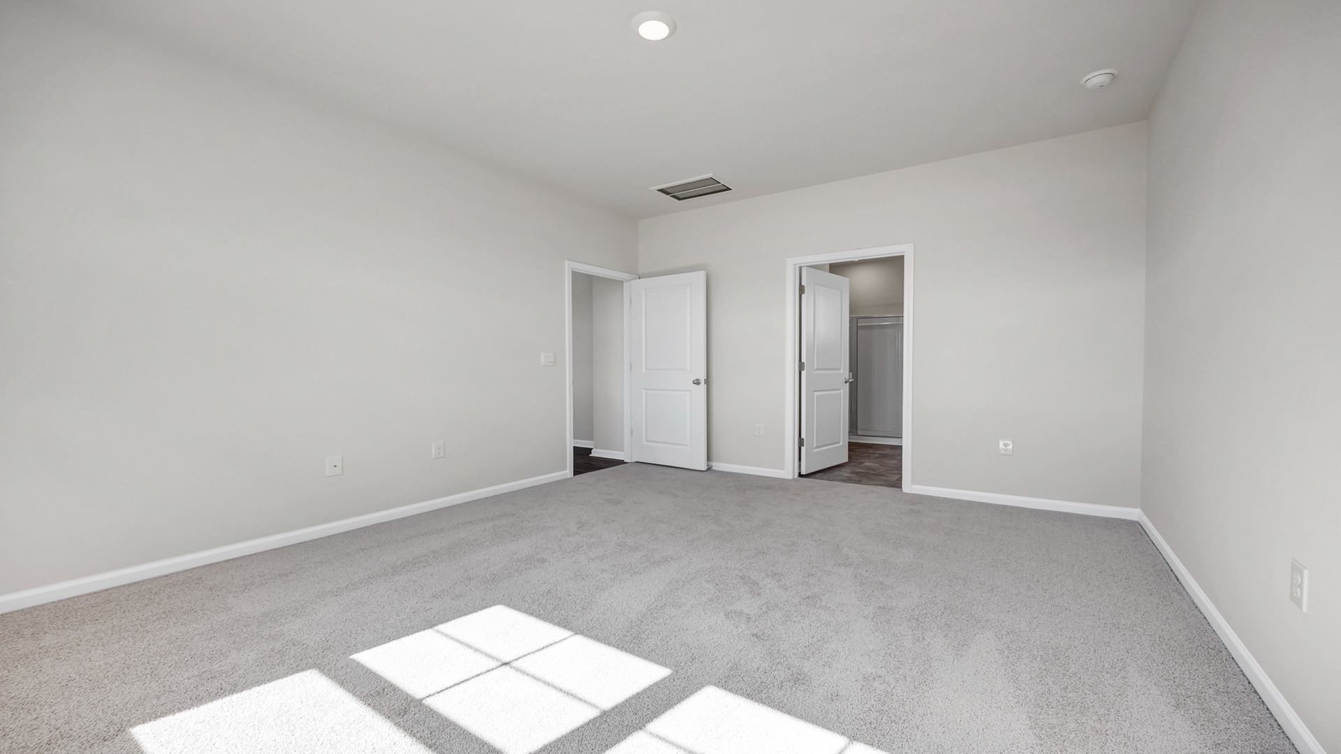 Primary bedroom with carpet floorings and natural light