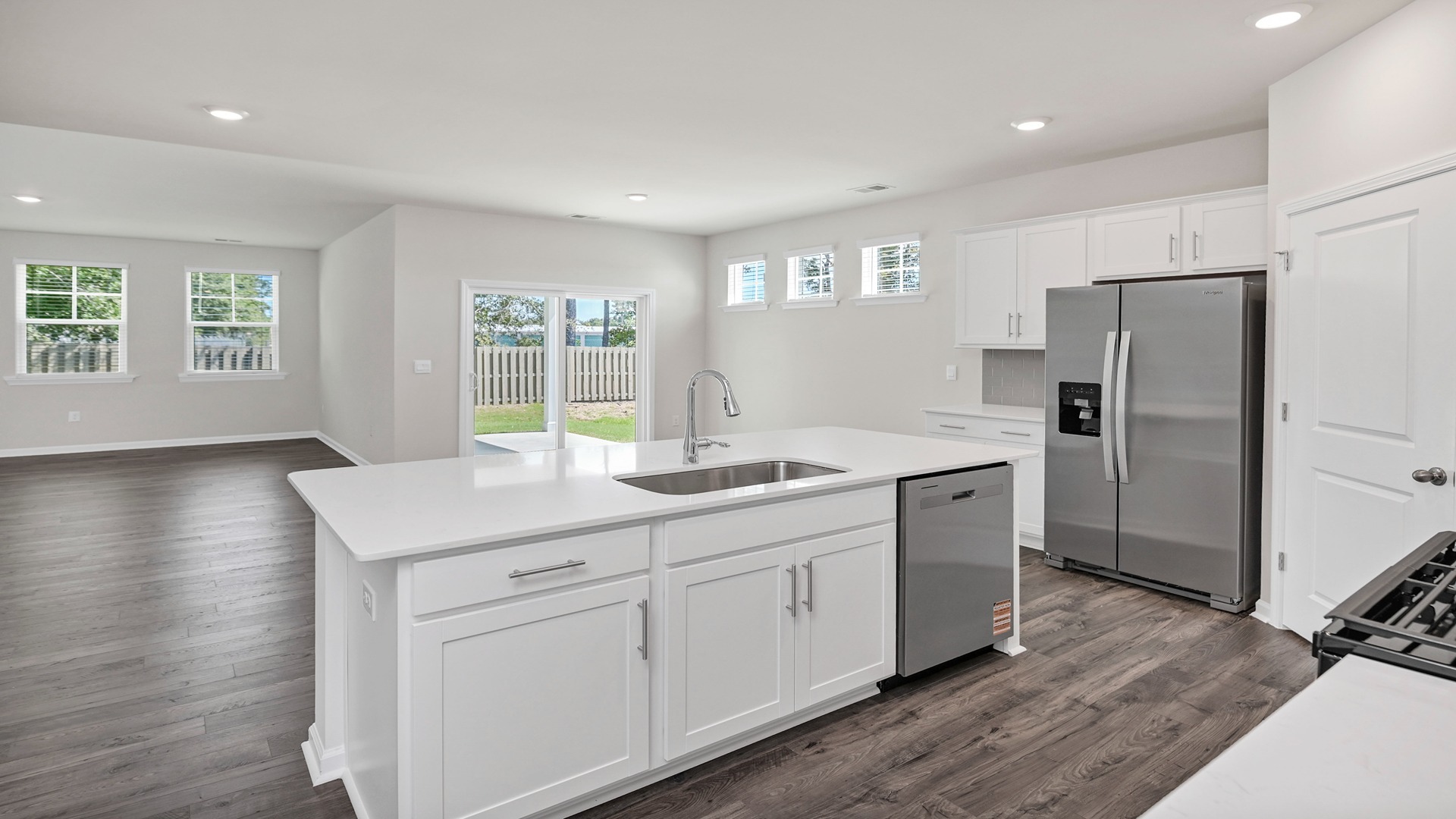 Floating kitchen island overlooks dining and living areas