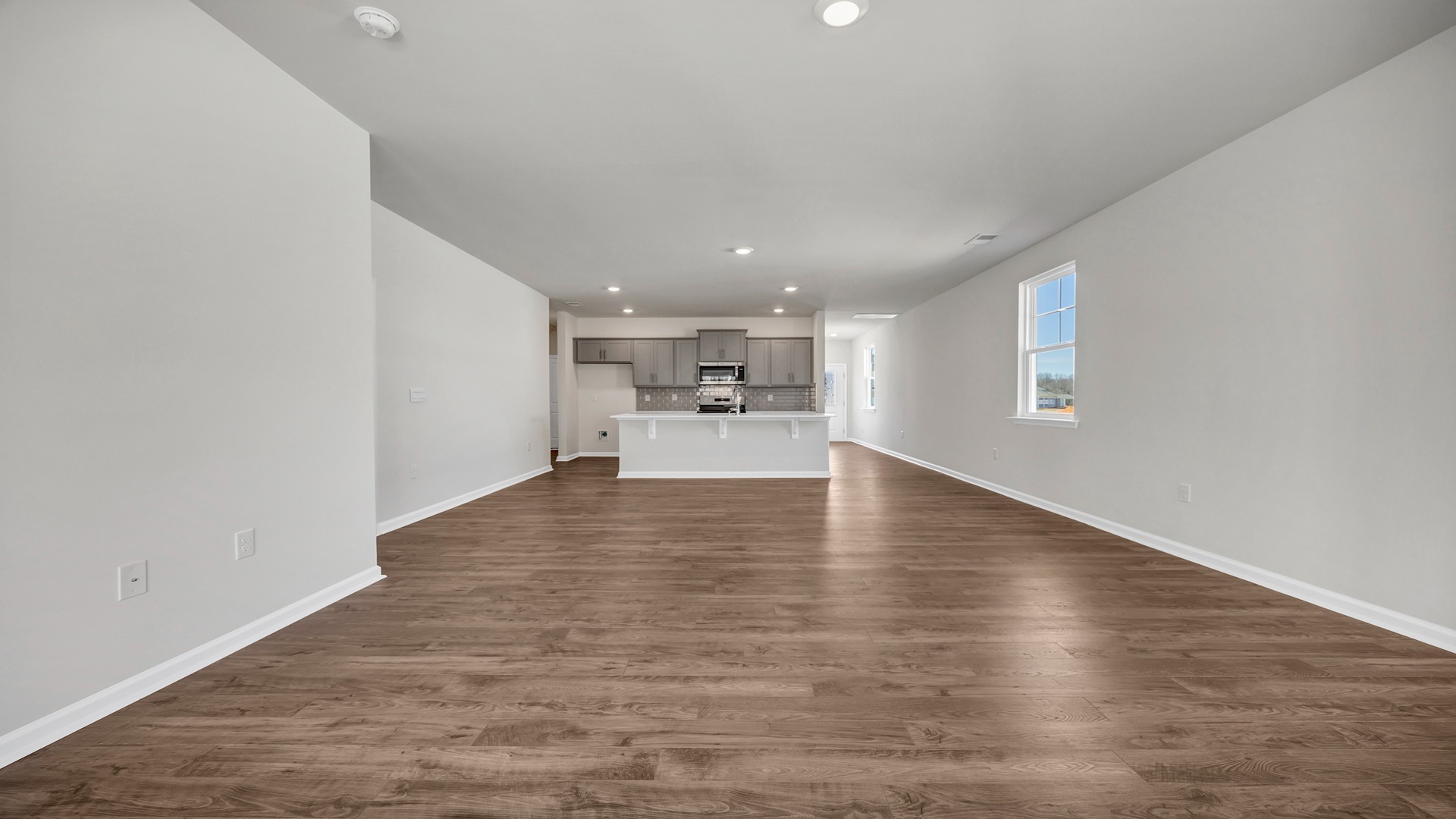 The living room is spacious with a window for natural light.
