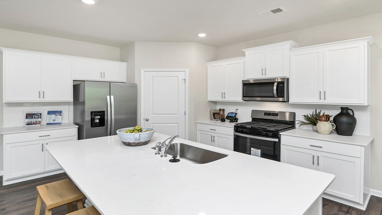 Modern white Quartz countertops in the kitchen and a spacious corner pantry