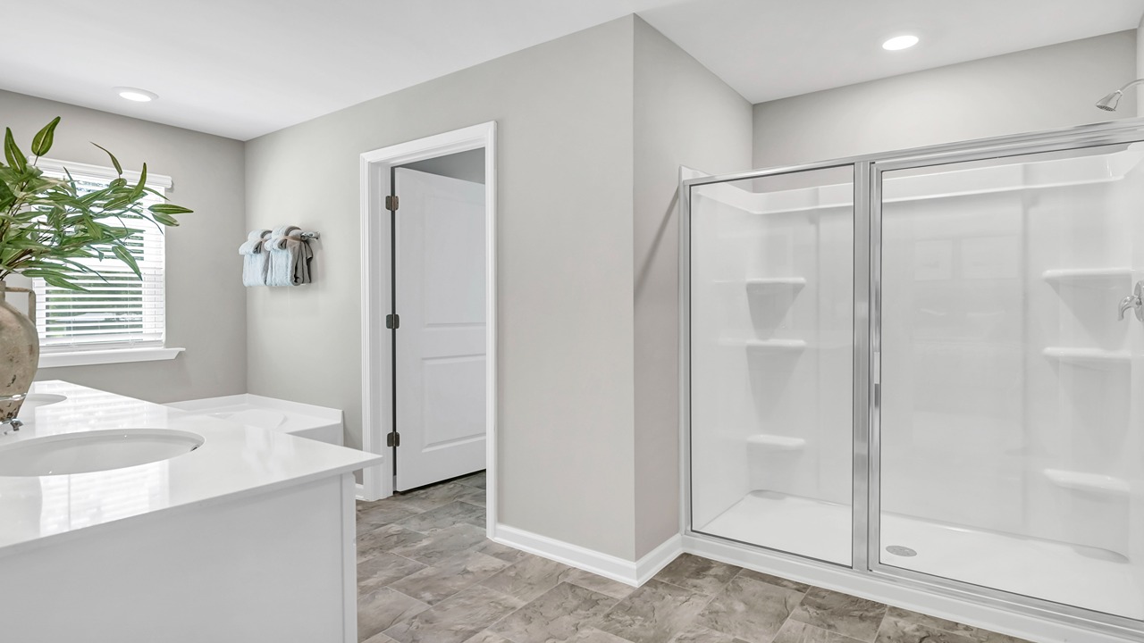 Spacious en-suite primary bathroom with a standup shower with glass doors