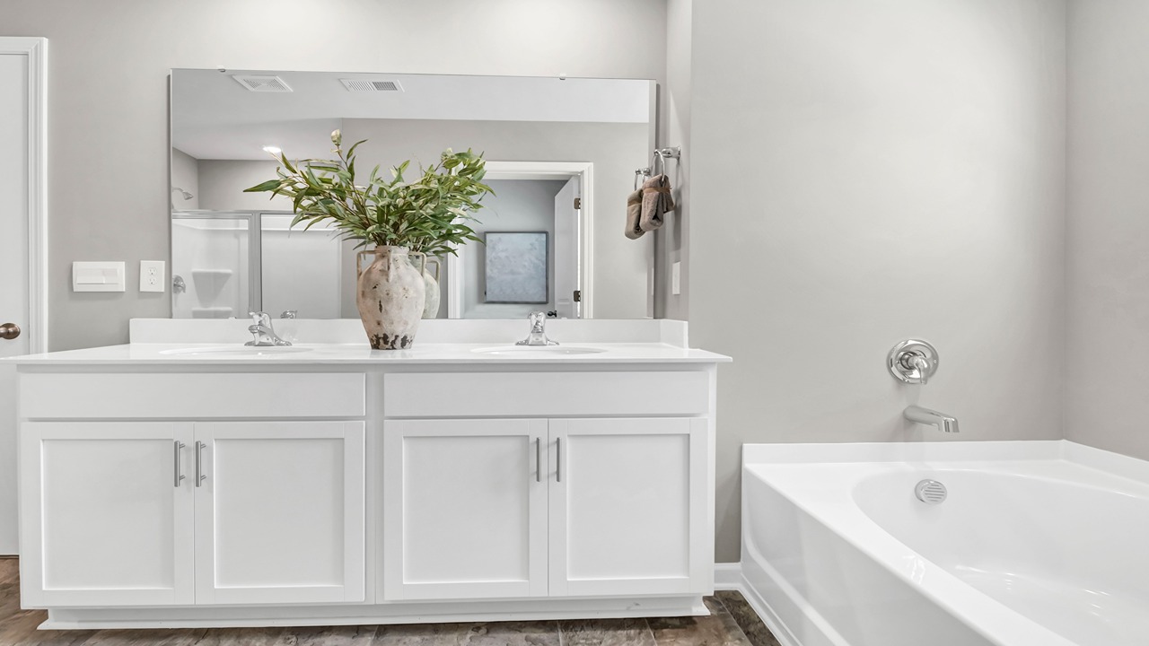 Double primary vanity with white cabinetry and quartz countertops