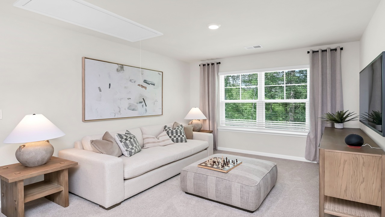 Upstairs living area with window for light and carpet flooring