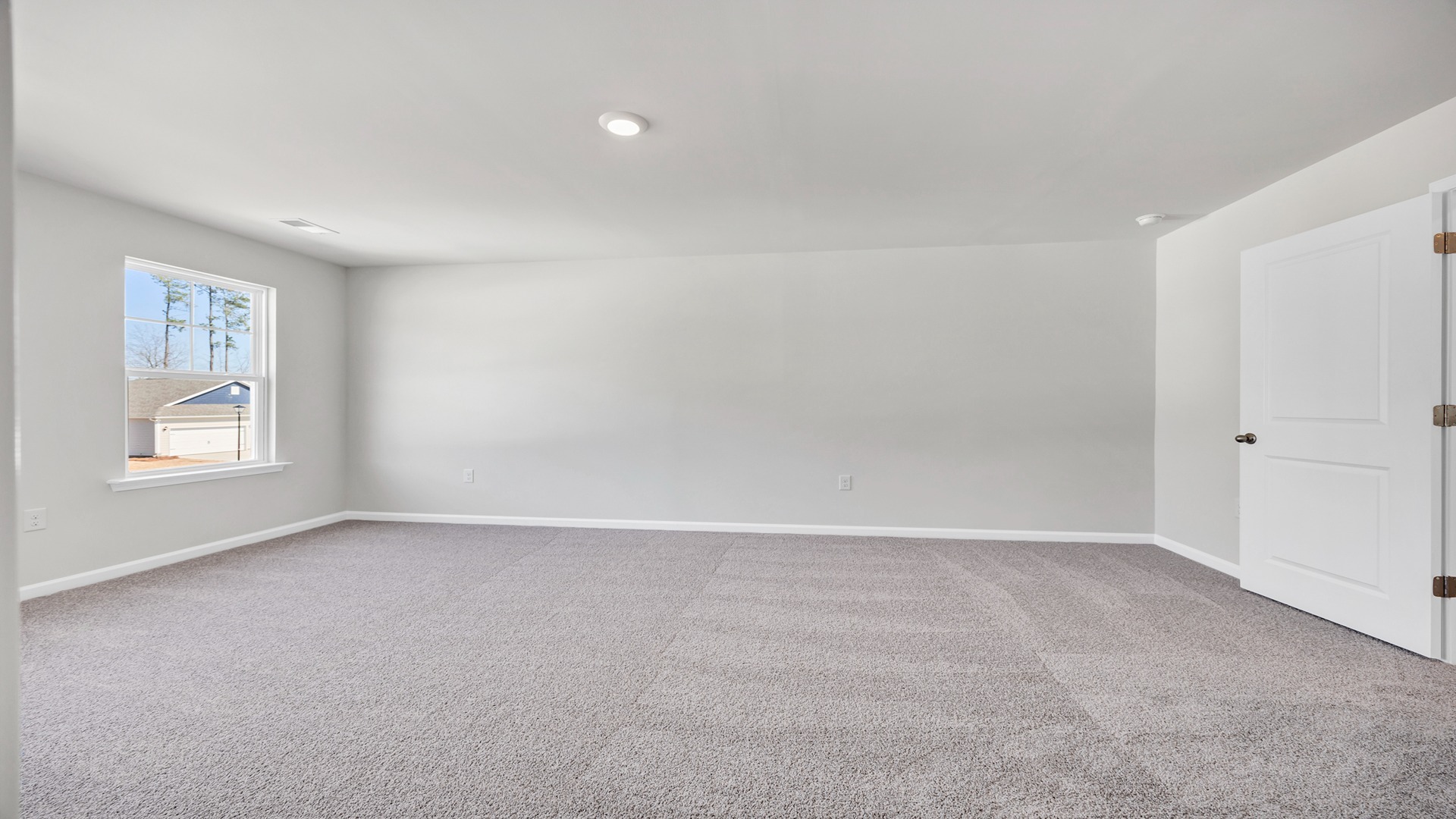 Primary bedroom upstairs with carpet flooring and natural light