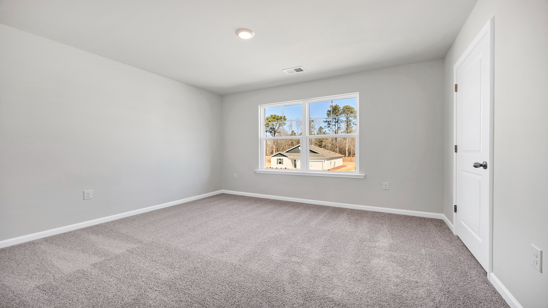 Bedroom 3 with a large window and carpet flooring