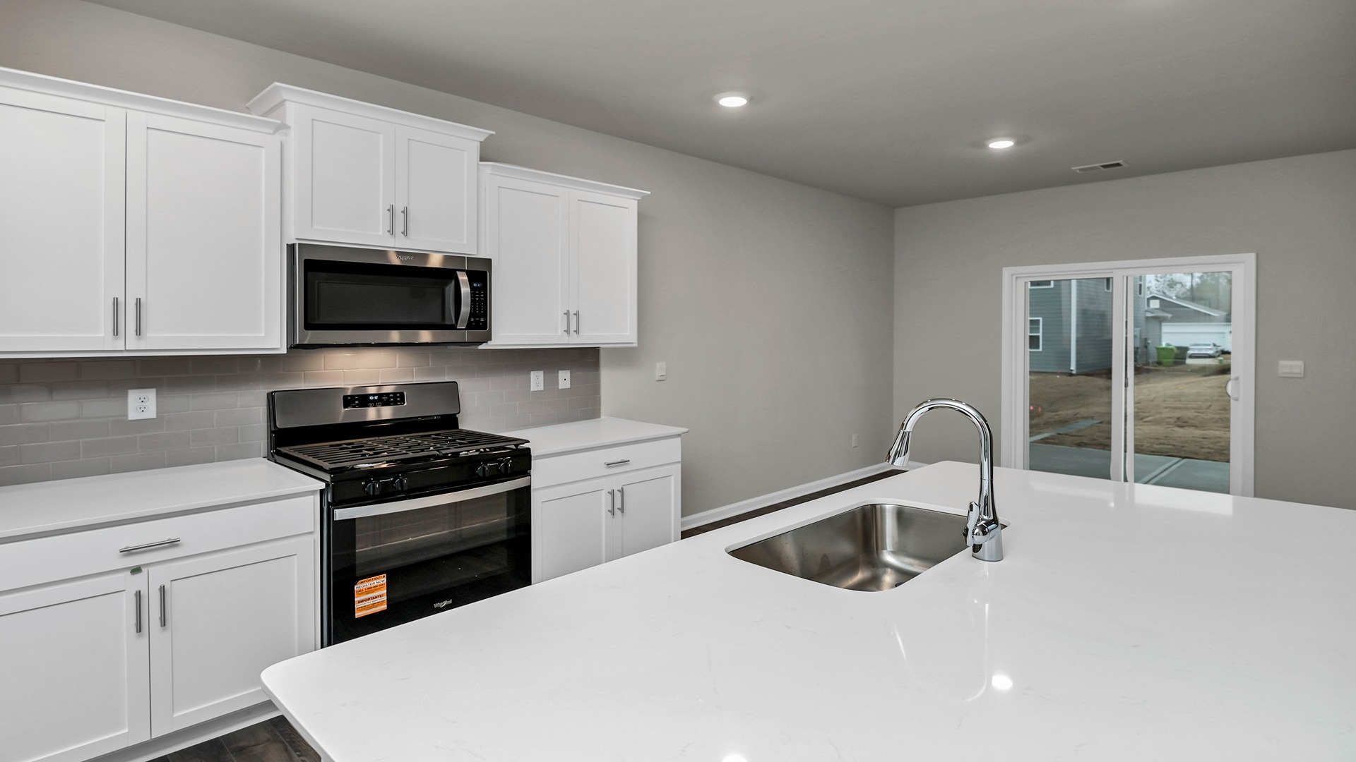 Sleek, white quartz countertops in the Elle kitchen in Leatherstone