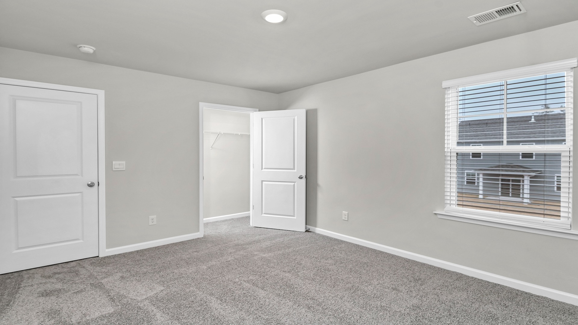 Bedroom 4 upstairs in the Elle floorplan with carpet flooring and a window