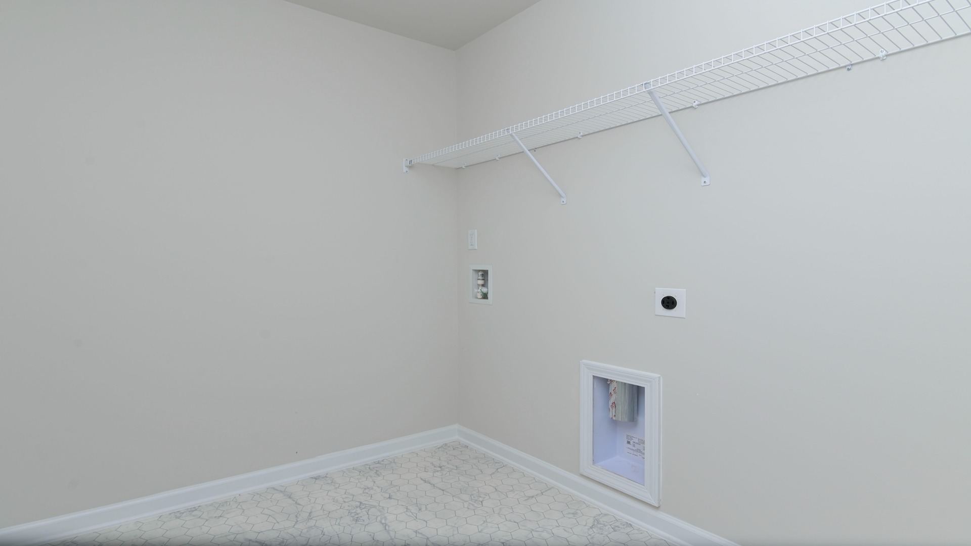 Laundry room upstairs in the Elle floor plan with wire shelving above