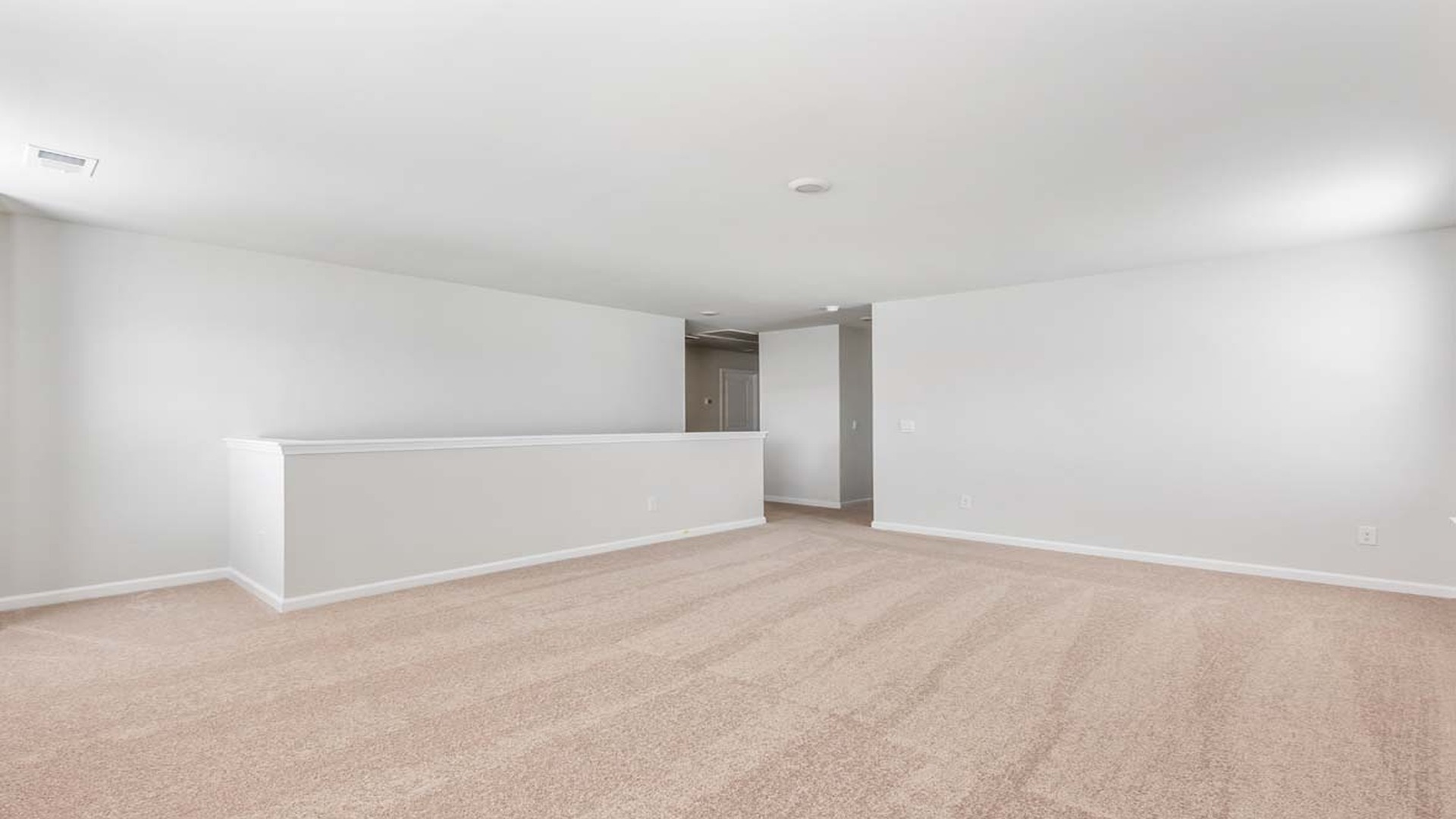 Large upstairs living area with several windows at the top of the stairs.
