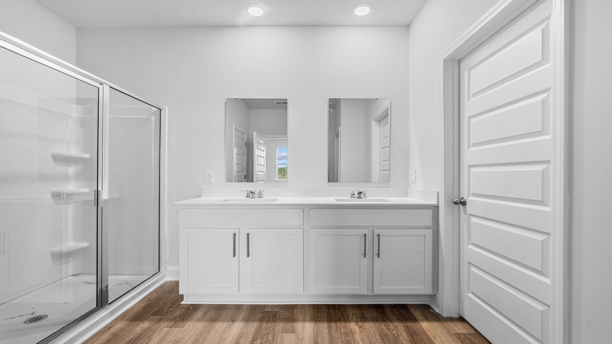 The primary bathroom features a double vanity and a standup shower.
