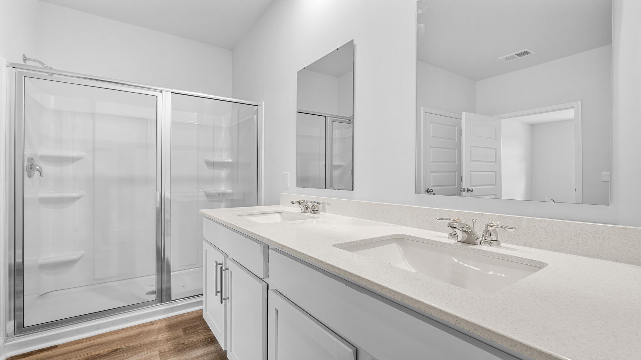 The primary bathroom features a double vanity and a standup shower.