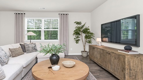 The living room is spacious with a window for natural light.