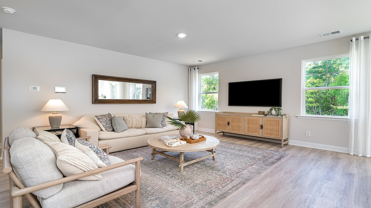 Spacious living area in new construction home with windows for light