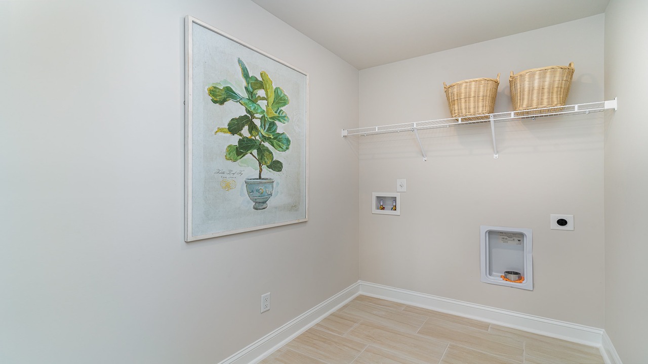 Laundry room in all home for sale with wire shelving above