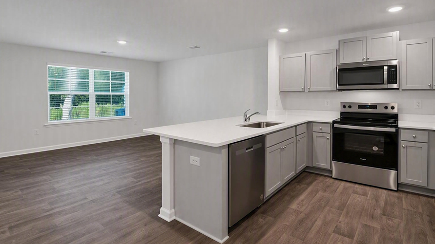 The kitchen bar in the new construction townhome overlooks the open living area