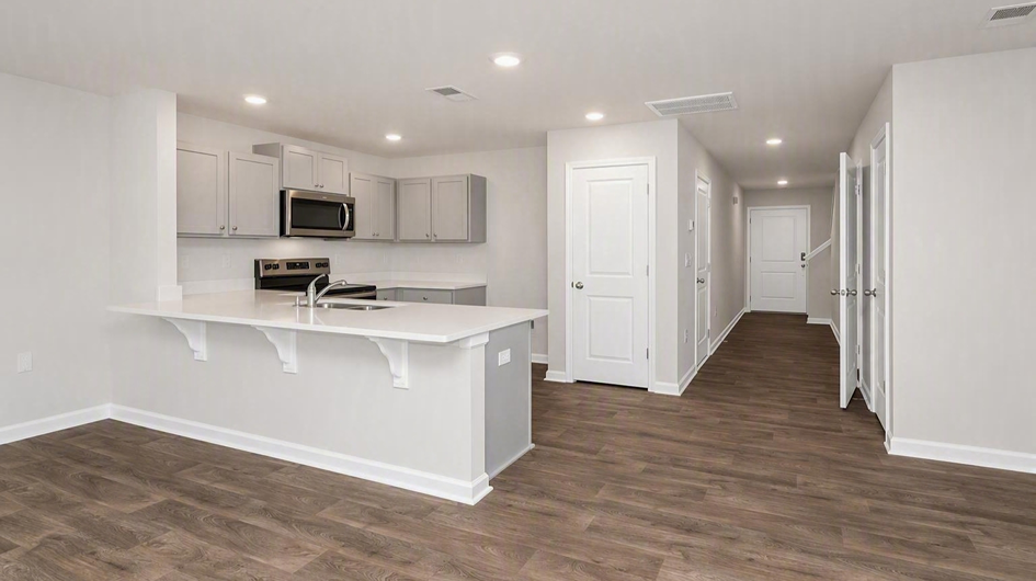 Front foyer of new construction townhome opens into the modern kitchen space
