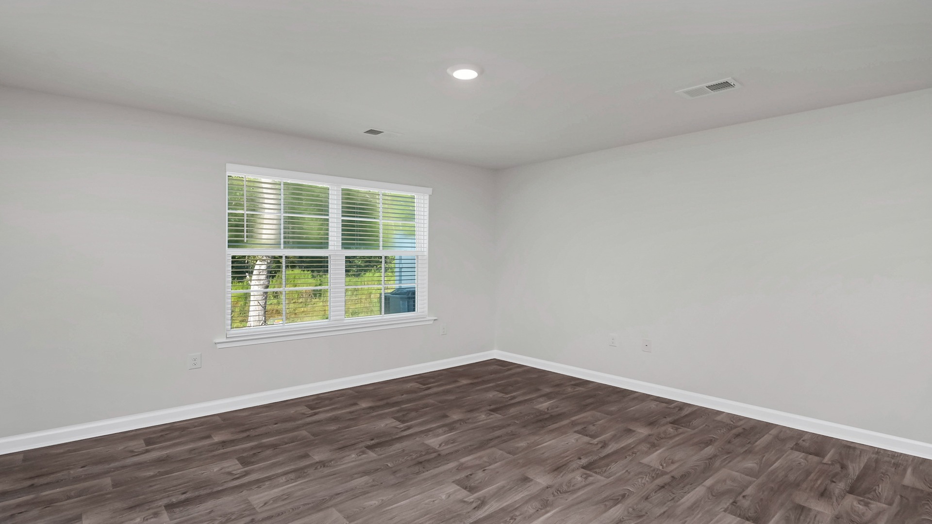 Living area with vinyl floors and a window facing the backyard