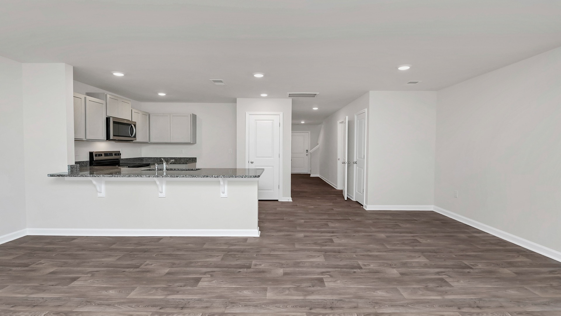 Kitchen and dining areas with matching vinyl floors and neutral-painted walls