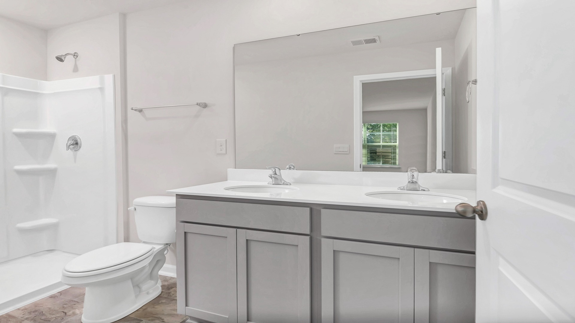 Primary bathroom with a double vanity and standup shower