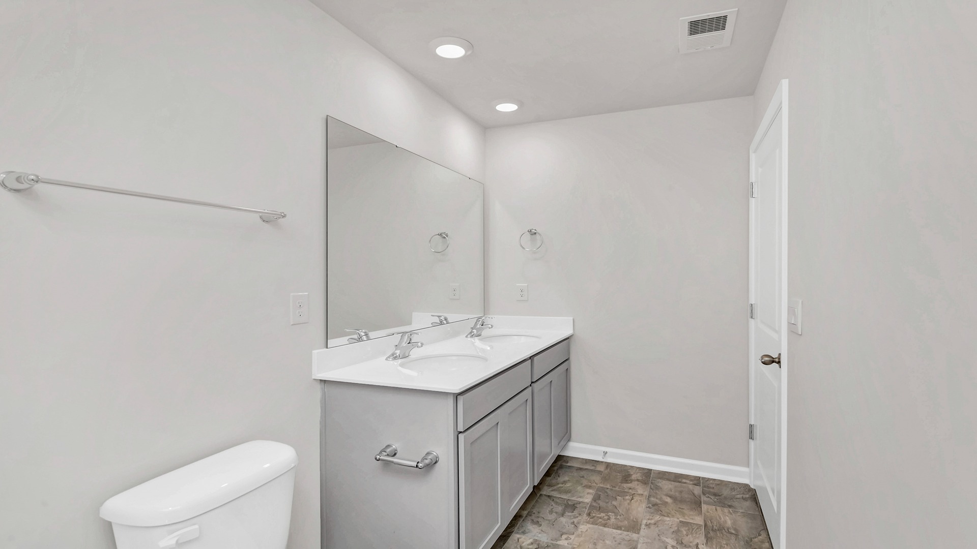 Primary bathroom vanity with gray cabinets and white quartz countertops