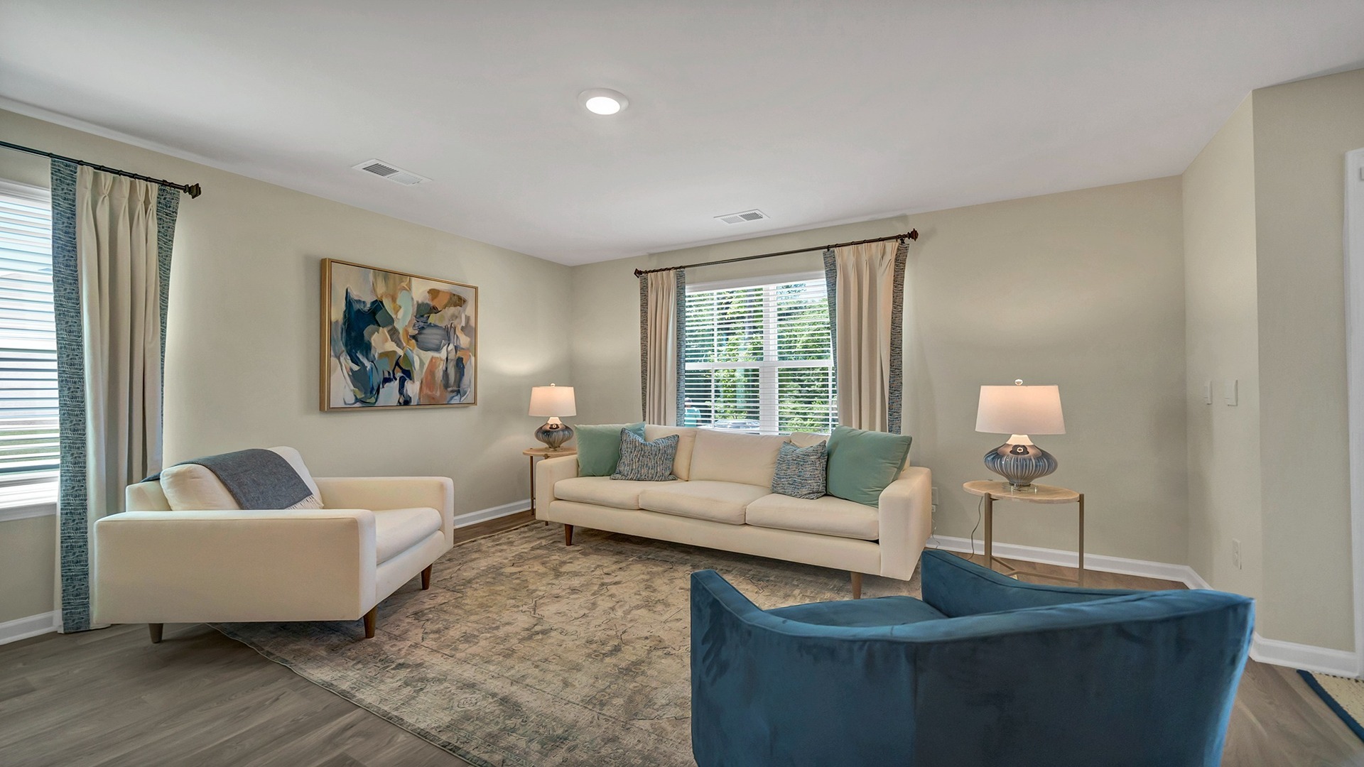Living area with several windows for light and vinyl flooring