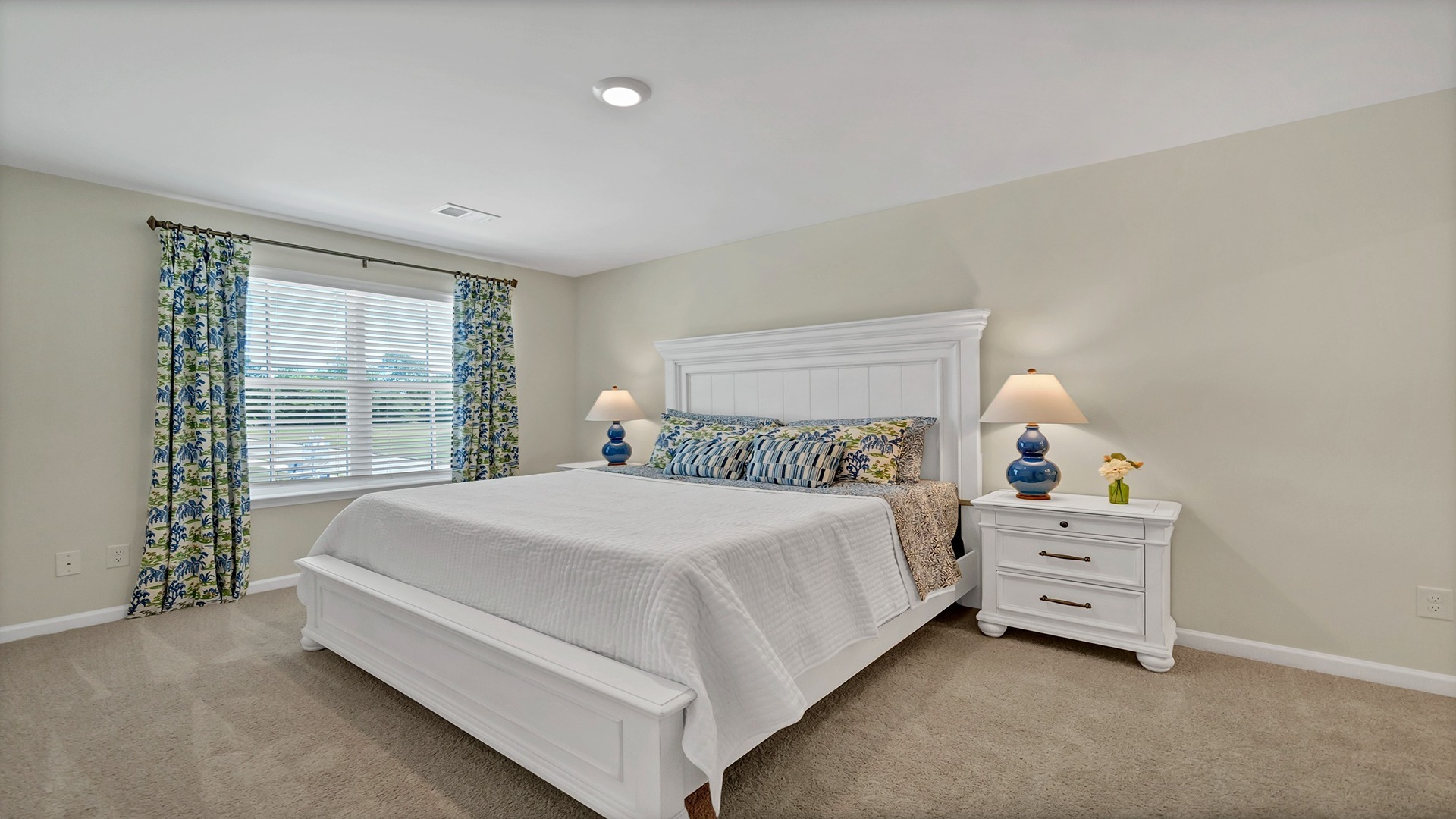 Primary bedroom upstairs with carpet flooring and a large window for light