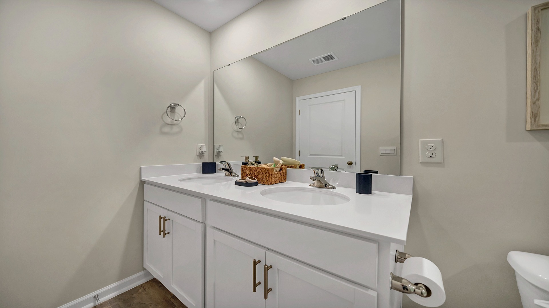 Double primary bathroom vanity with quartz countertops and white cabinetry