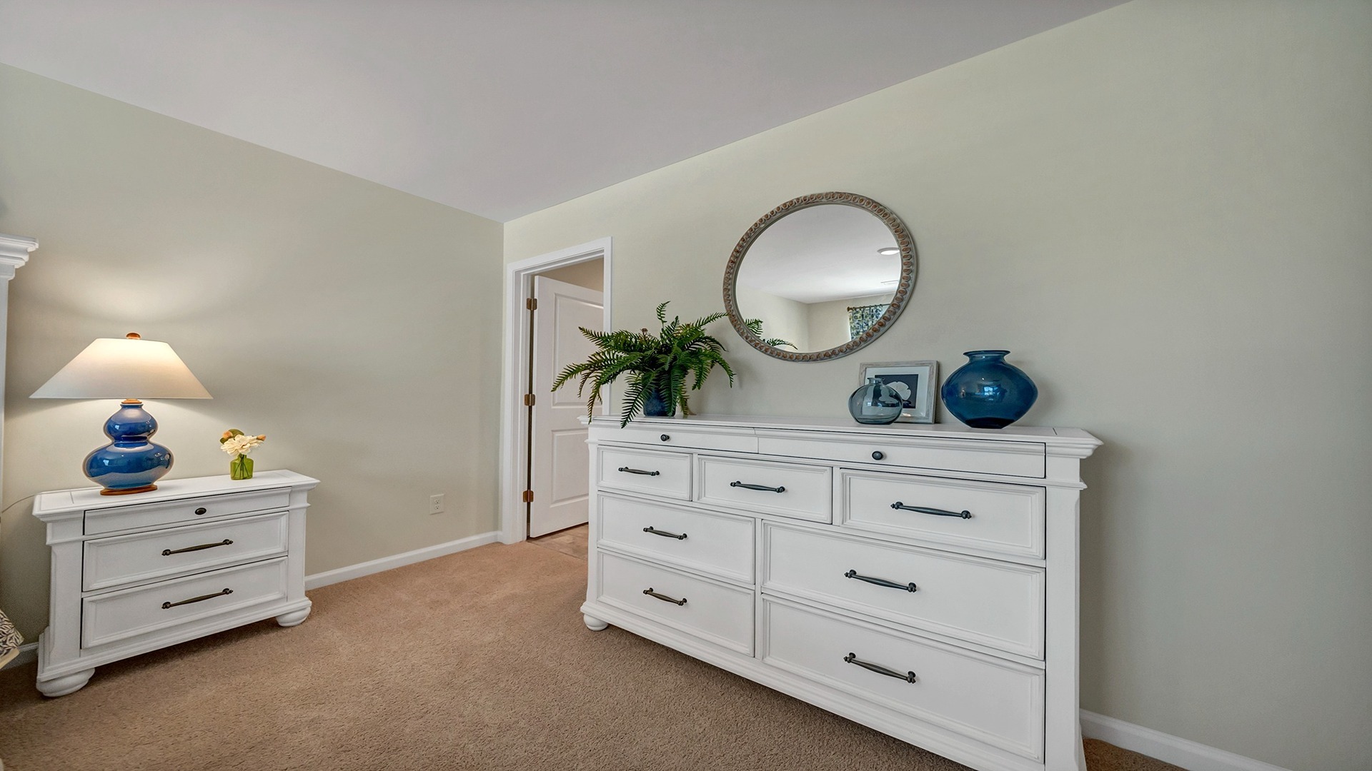 Carpet flooring and neutral-colored walls in primary bedroom