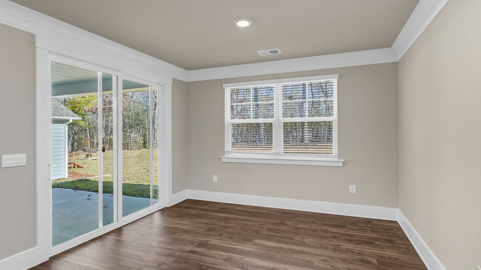 Dining area with glass sliding doors and a window for natural light in Dorset Ridge