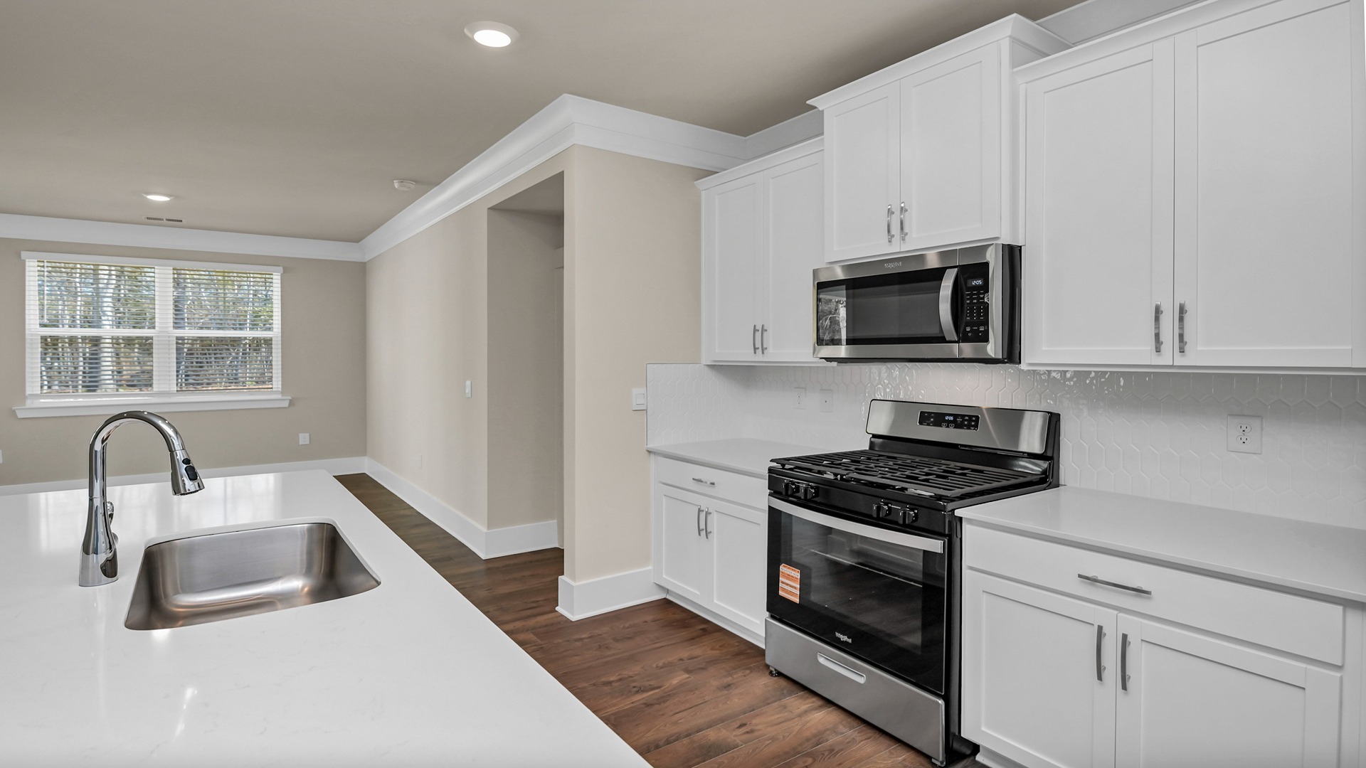 Tile backsplash and brand-new stainless-steel appliances finish the kitchen space in new construction home