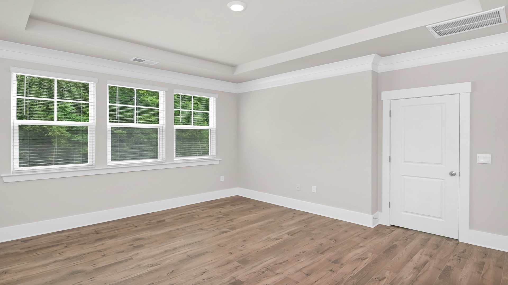 Primary bedroom privately at the back of the new ranch-style house
