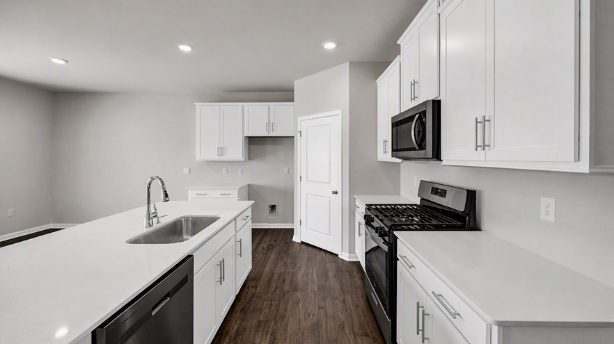 Corner pantry and quartz countertops in the kitchen of new construction home for sale