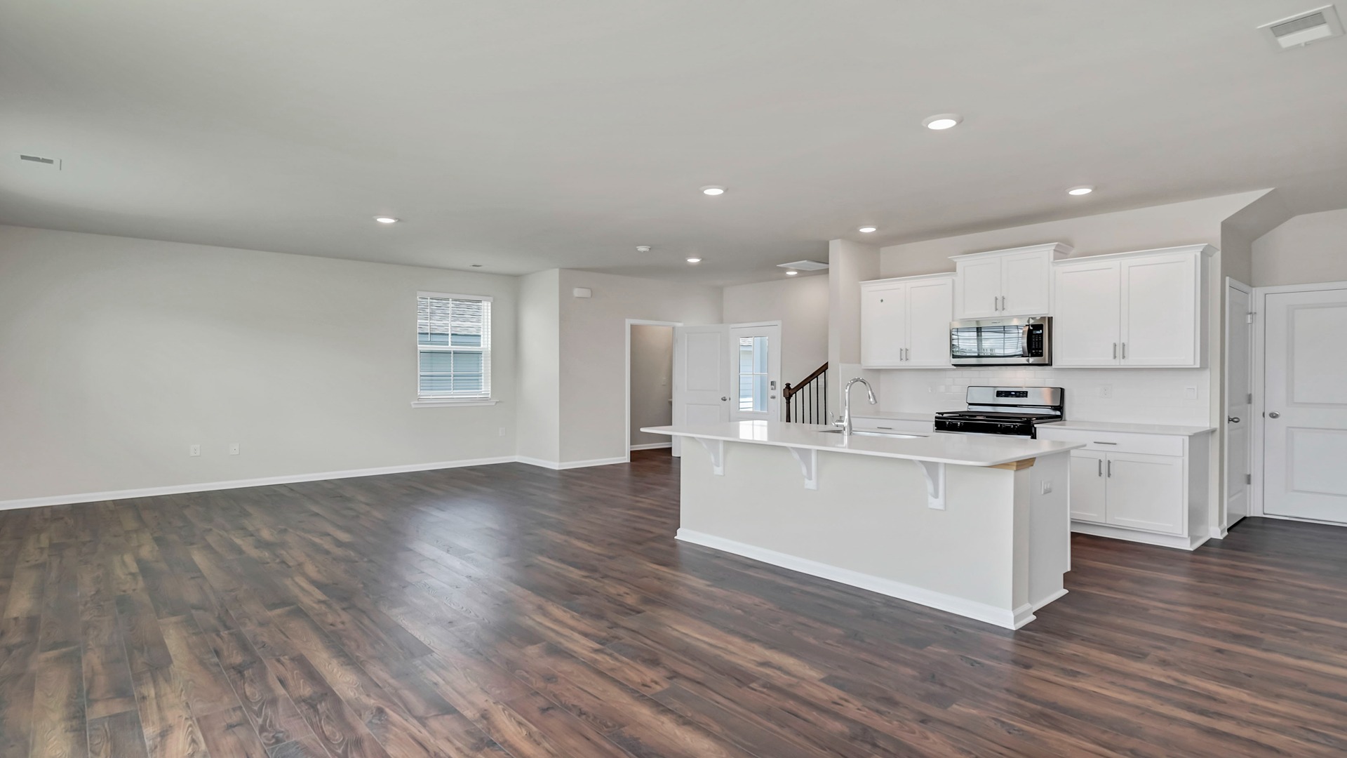 Open kitchen and living spaces finished with matching vinyl floors