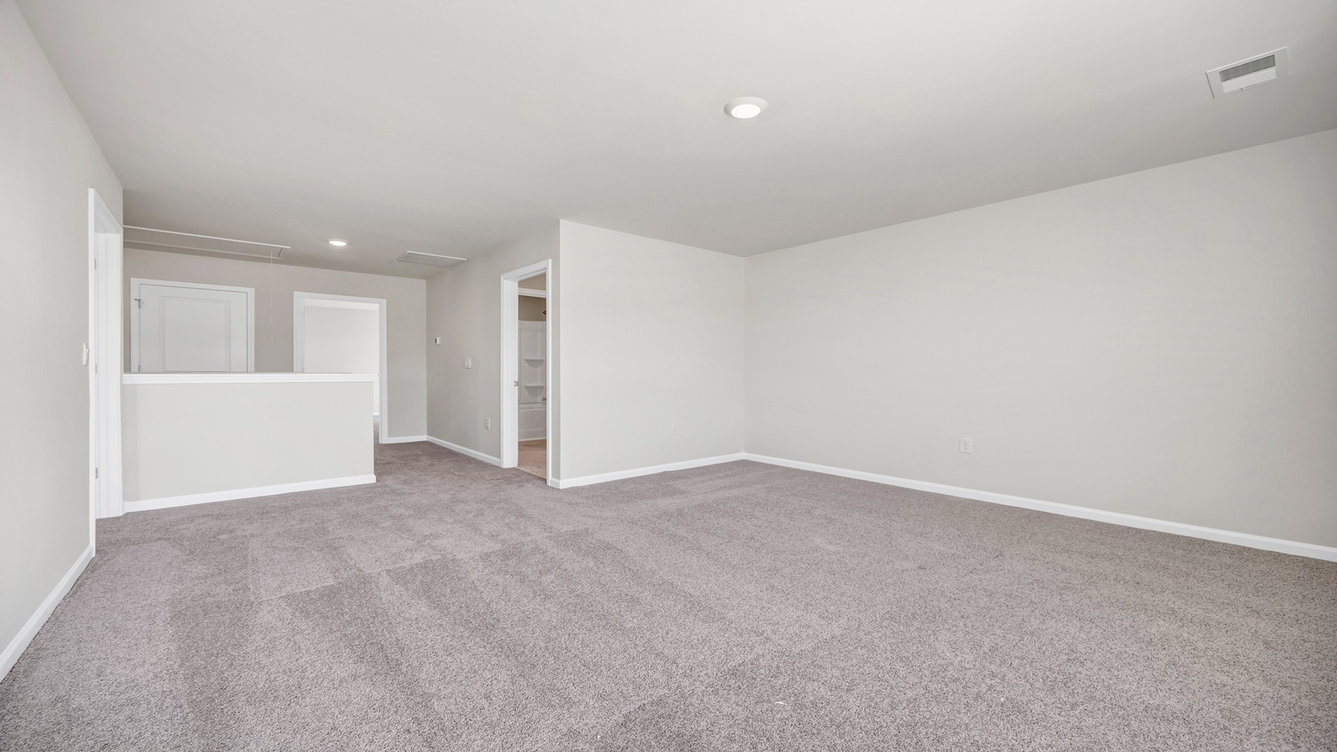 Carpeted upstairs living area in two-story home for sale in Sumter, SC