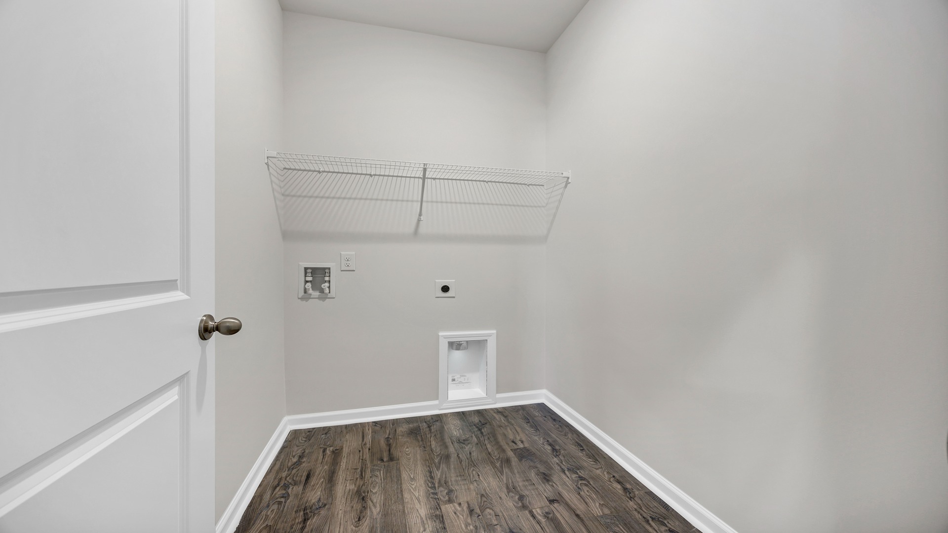 First-floor laundry room with wire shelving above in the Manning for sale in Meadowview Plantation