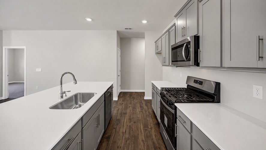 White quartz countertops and new stainless-steel appliances come in the kitchen of home for sale