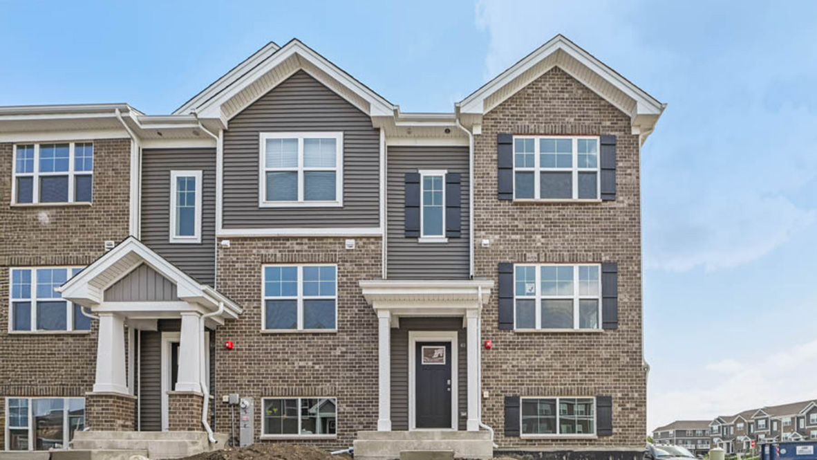 Exterior photo of end unit townhome with brick and grey vinyl siding