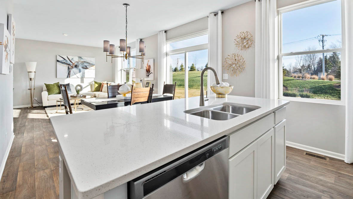 Kitchen island over looking dining and great room with sink and dishwasher
