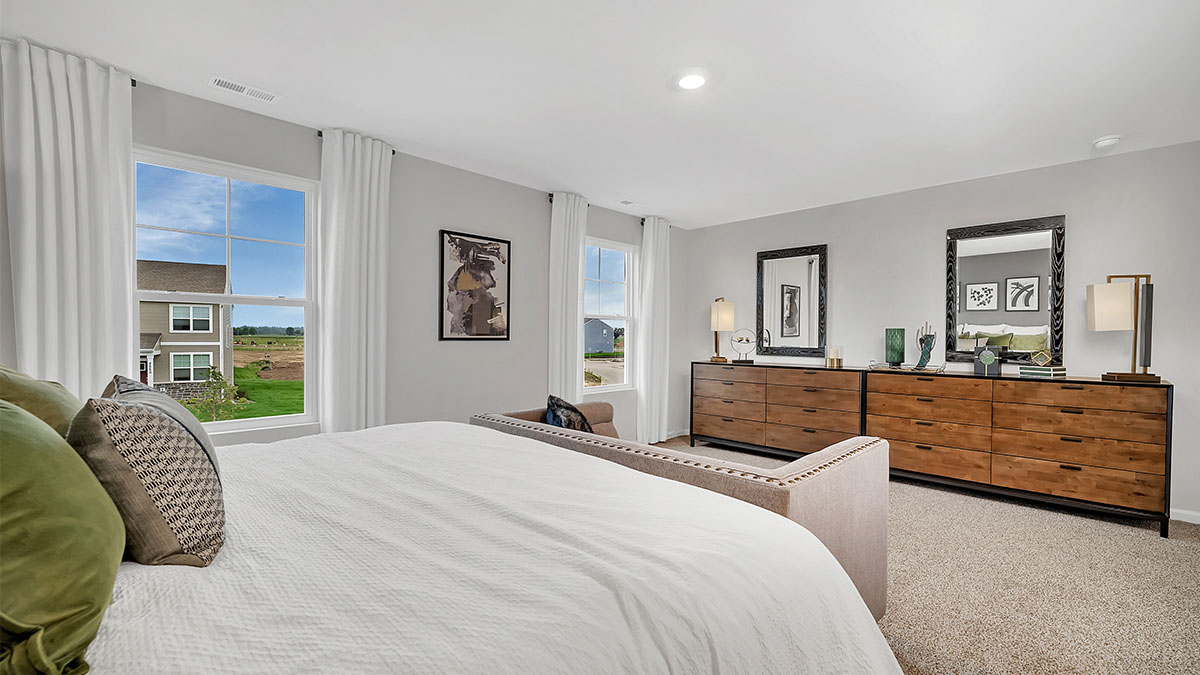 primary bedroom with a king bed, and night stands on either side and two windows